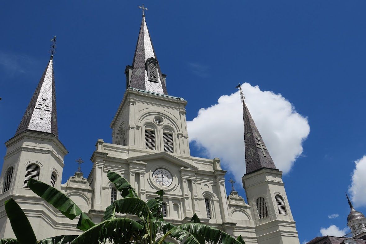 The left and right steeples of St. Louis Cathedral are topped with Adinkra symbols.