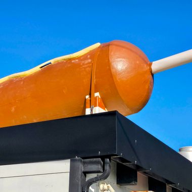 The World's Largest Corn Dog is a 30-foot-long fiberglass structure on the roof of the Original Pronto Pup.