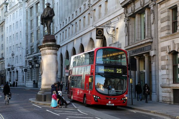  The statue of James Henry Greathead with a bus passing on one side.