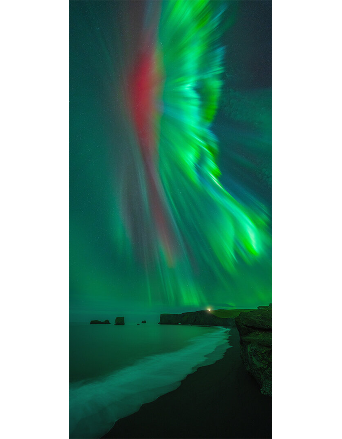 The black sand beaches and oddly shaped sea stacks at Dyrhólaey, along Iceland’s southern coast, have had starring roles in many a movie and tv show, but here they are overshadowed by a massive, rare red aurora. The brilliant crimson body, framed by green “wings,” reminded photographer Luis Solano Pochet of the beautiful quetzal, a bird found in his native Costa Rica. Red auroras are only slightly more common than finding a tropical bird in Iceland: The color results from charged particle collisions with oxygen in the very highest portions of our atmosphere, about 200 miles or more above us, and only during specific solar wind conditions.