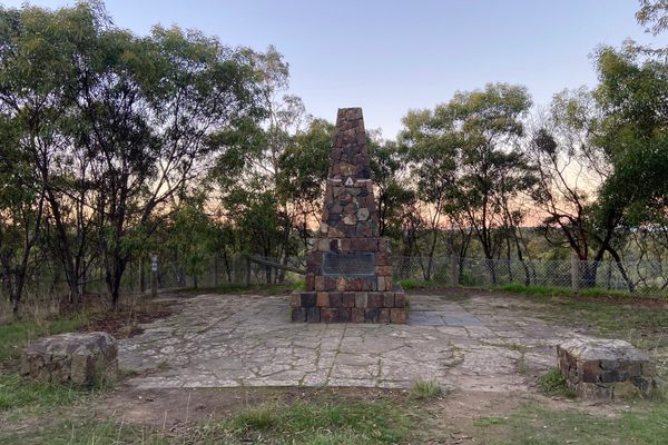 The cairn is surrounded by eucalyptus trees.