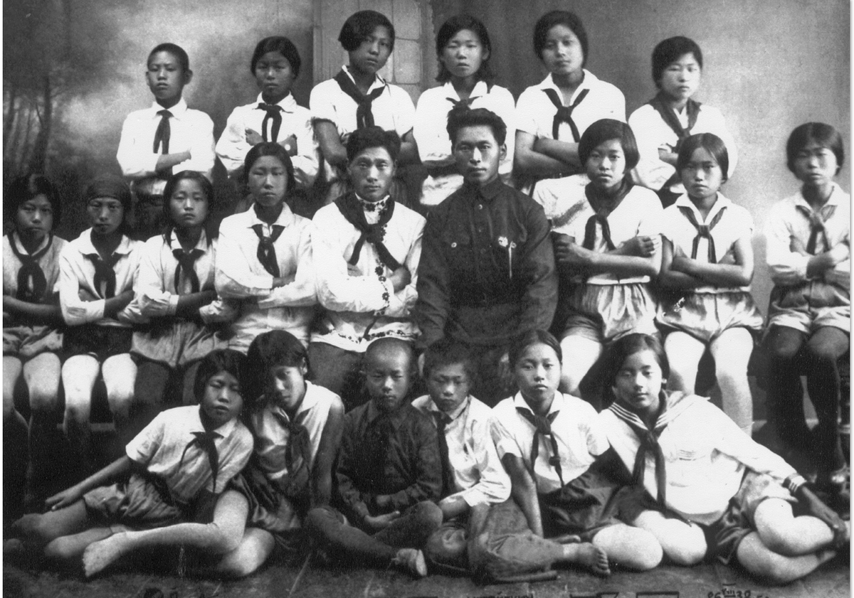 Korean schoolchildren wearing red Pioneer ties, with their teacher (fourth from right in the middle row) and the young leader of the school Lenin Pioneer Organization (next to the teacher), in the mid-1930s, shortly before the deportation of Koreans from the Far East to Central Asia.