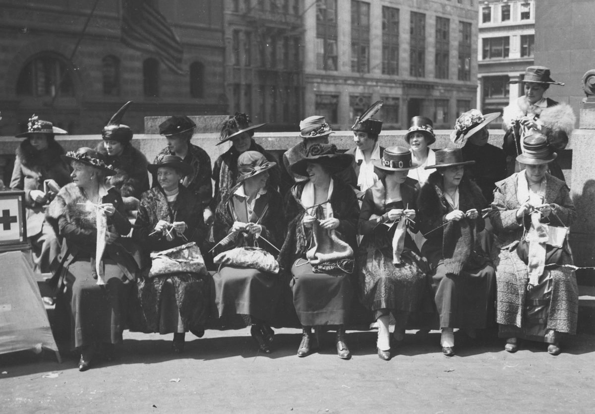 Women knit at the Red Cross Knitting Booth while waiting for their trains at New York's Grand Central Station, 1918.