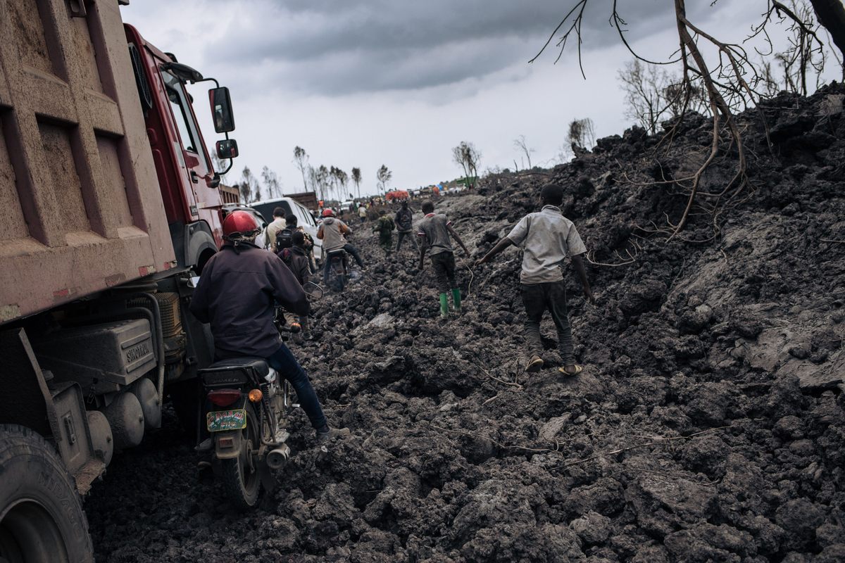 Motorbikes and trucks make their way through the solidified lava flow in the northern neighborhoods of Goma.