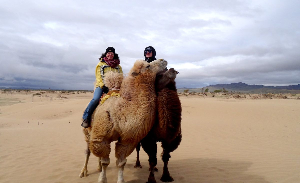 Anne Broadbridge (left) and guide Emma Hite ride Bactrian camels on the Mongolian steppe. For millennia, nomads have used the camels as pack animals.