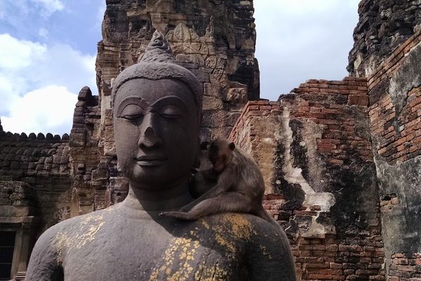 A macque sits on the Buddha’s shoulder.