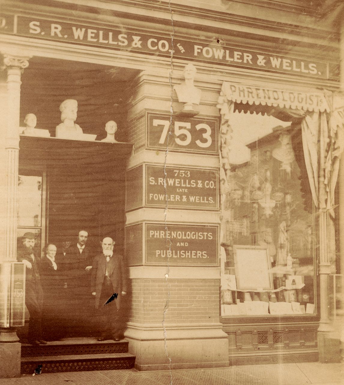 Photograph of Samuel Robert Wells, Charlotte Fowler Wells, and Lorenzo N. Fowler standing in the doorway of 753 Broadway, probably in the 1880s.