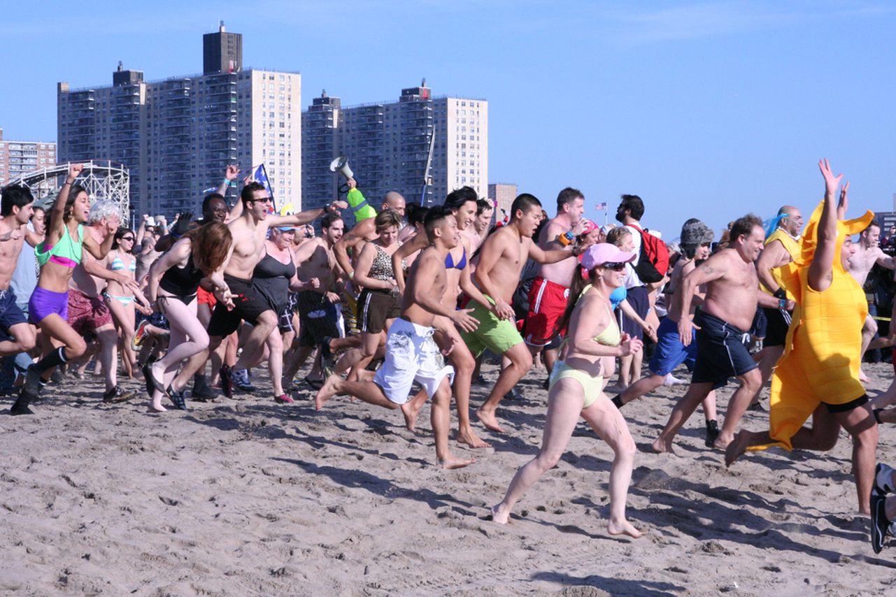 Swimmers run to the frigid water at the 2012 New Year's Day Coney Island Polar Bear Club Plunge