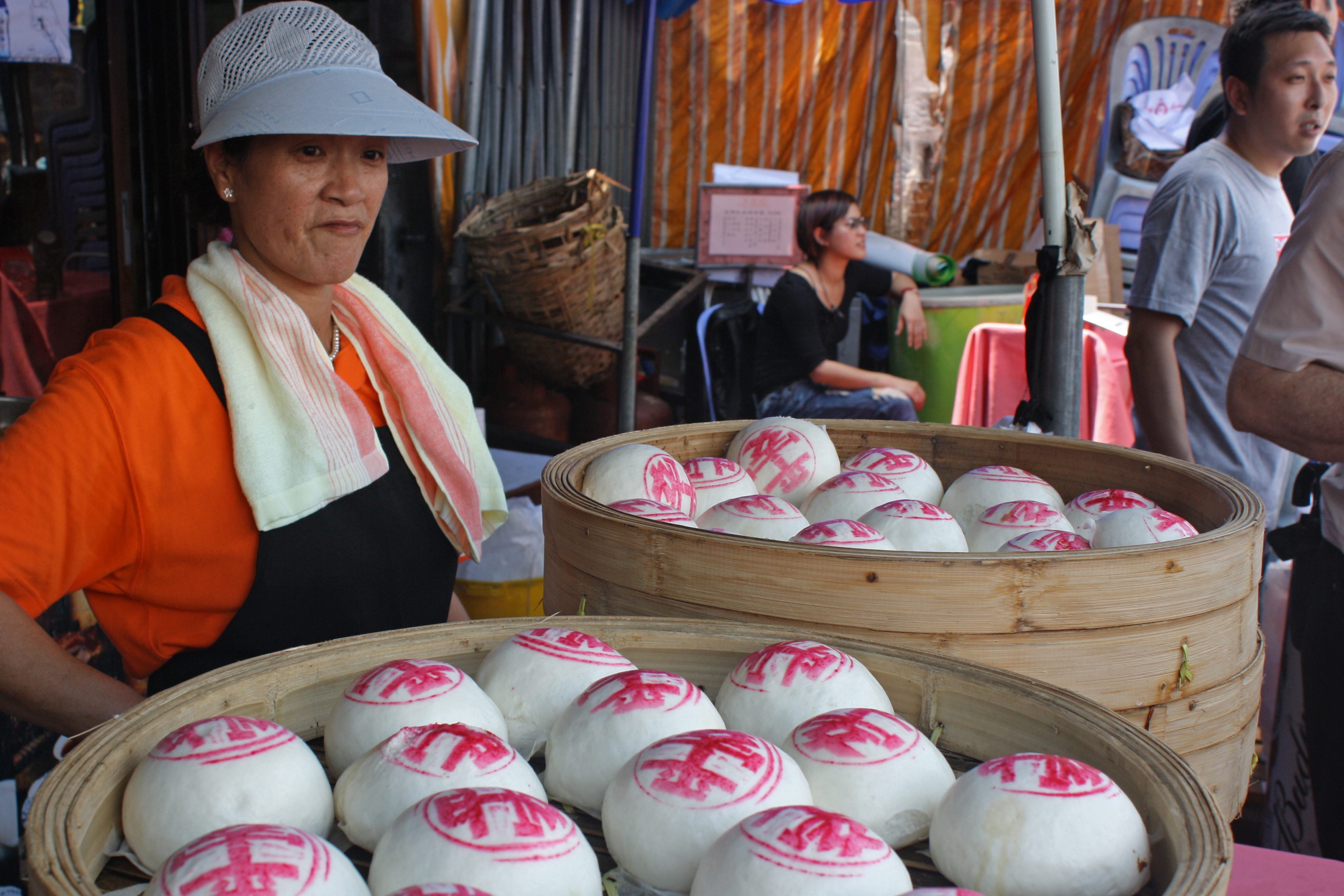 A bun salesperson looks on.
