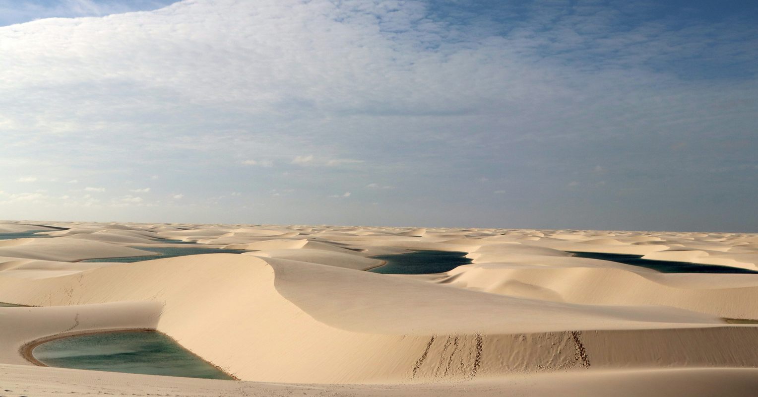 The rolling sand dunes of Lençóis Maranhenses in Brazil.