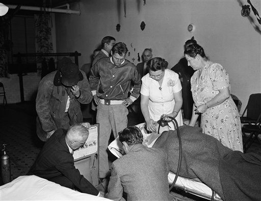 A nurse administers oxygen to a smog victim at an unidentified emergency triage location.