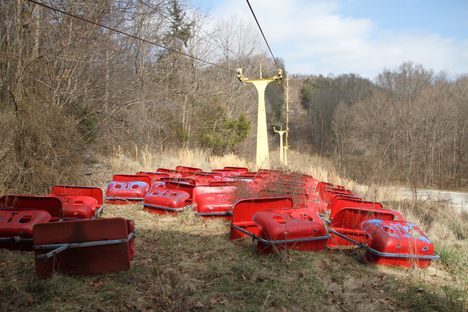 Chairs from Guntown's original chairlift lay rusty below it.