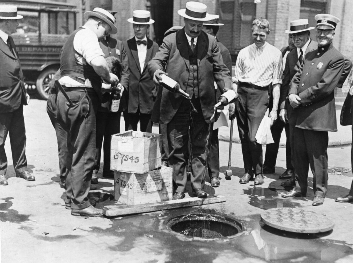 Pouring out bottles of alcohol during national Prohibition.