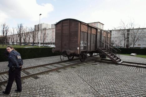 A policewoman guards the railway car memorial at Drancy in 2005, after an attempt to burn it. 