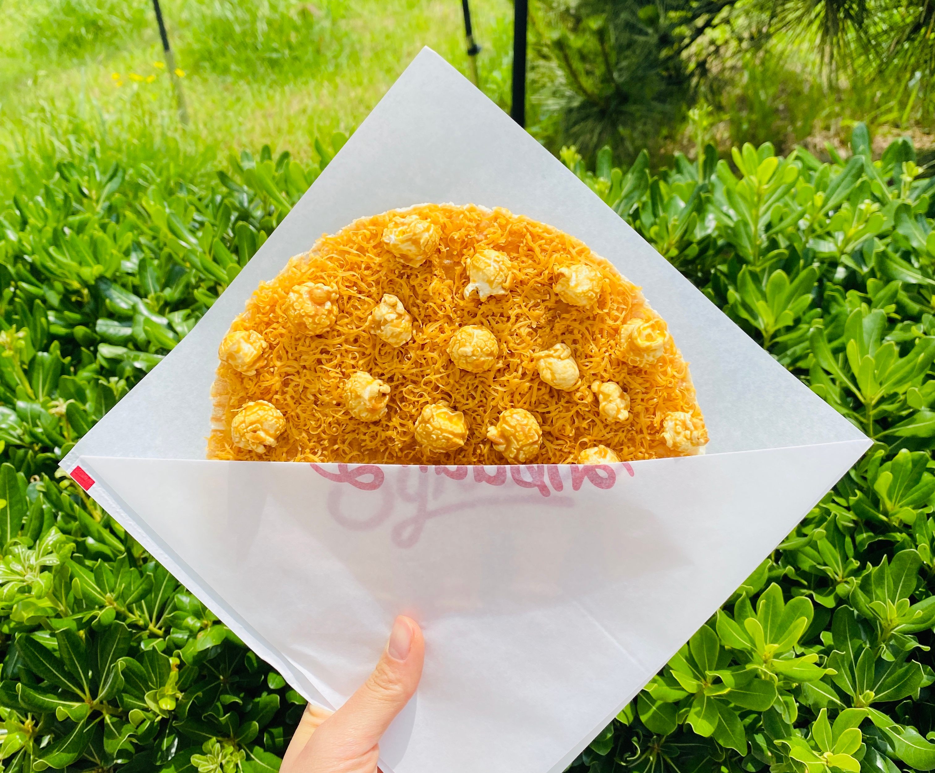 This handheld waffle is covered with brunost shavings and popcorn.
