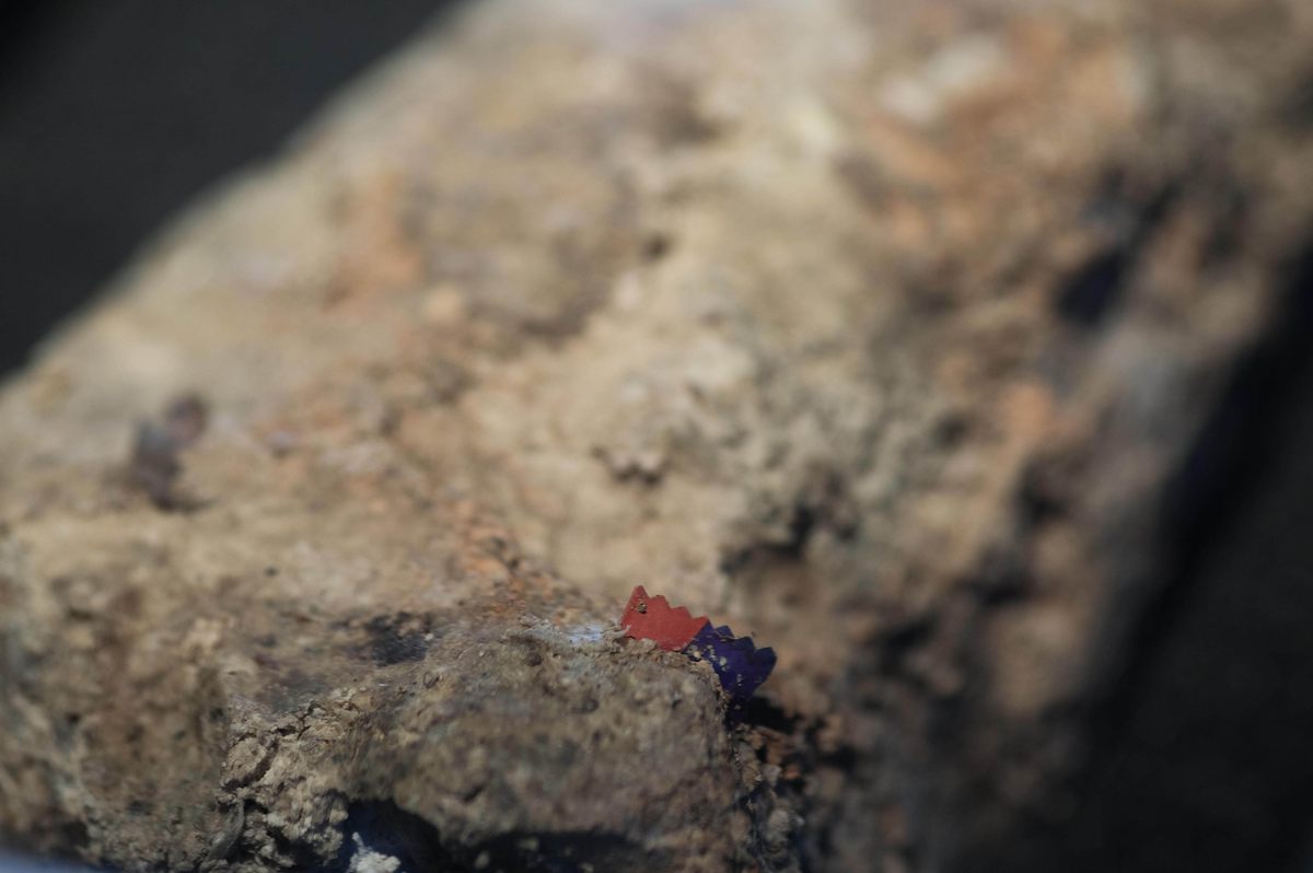 The perforated edges of a candy wrapper protrude from the fatberg's marbled surface.