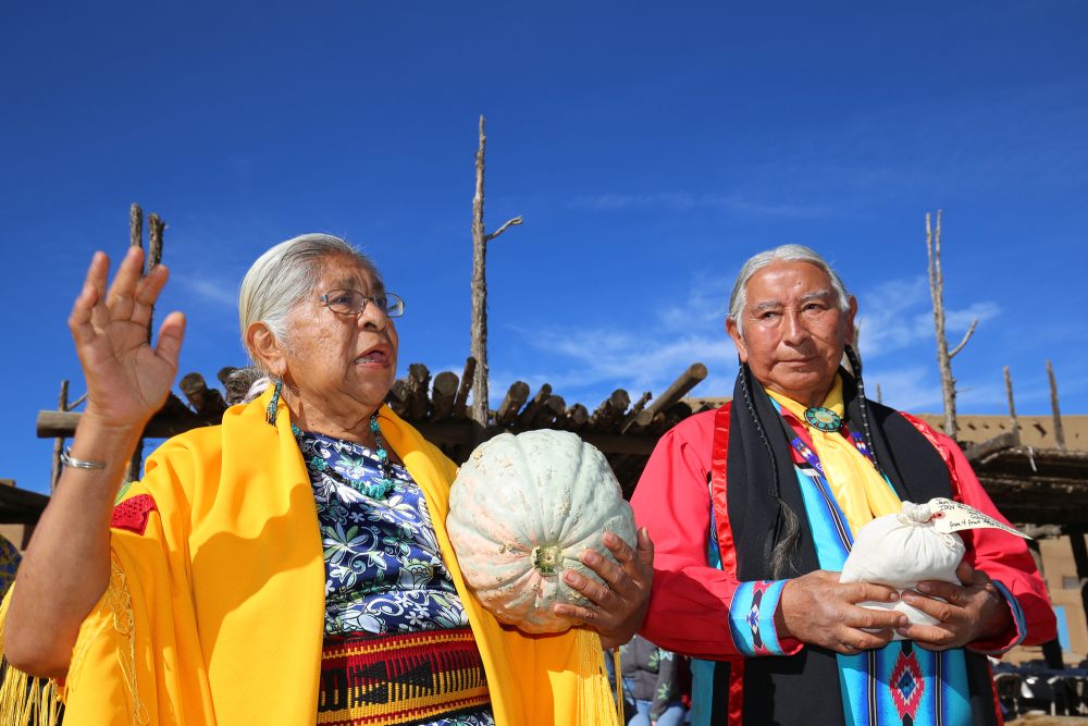 Henrietta Gomez and Gilbert Suazo, Sr., receive a Taos Pueblo squash in 2018. 