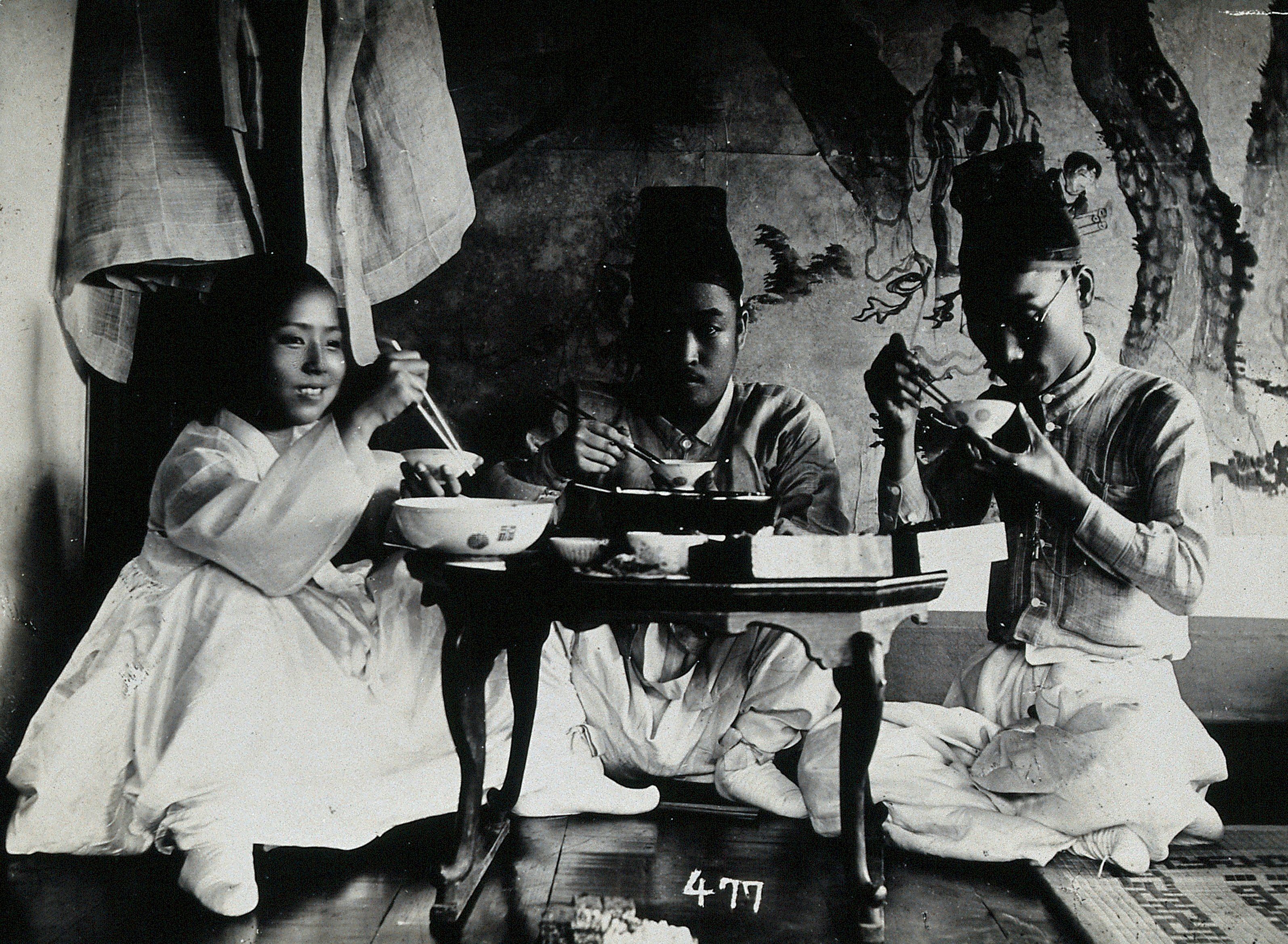 A group of people enjoying a meal in 1900.