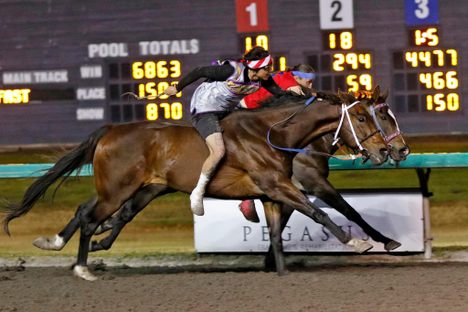 Riders Azeri Coby (foreground) and Darren Charges Strong (in red) duel it out in an Indian Relay race at Emerald Downs in Auburn, Washington.