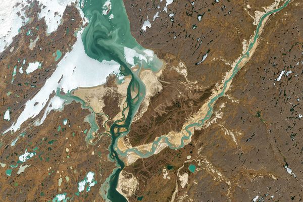 Amid ice and tundra, the lighter Hayes River flows from the northeast (top right) into the dark Back River in Nunavut, Canada, but remains distinct from it for 10 miles.