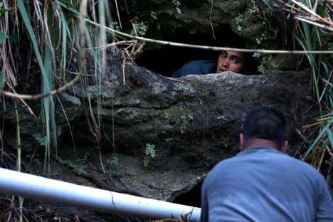 Directing water from a cave spring to drinking water containers in Corozal, Puerto Rico, in October 2017.