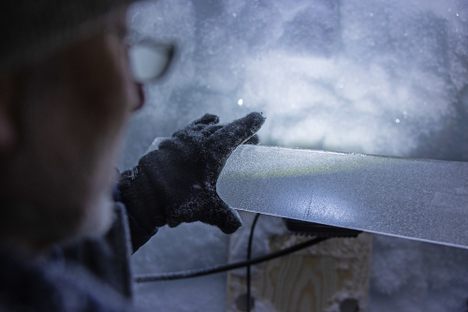 Sepp Kipfstuhl of the East Greenland Ice-Core Project examines a sample taken from where fast-moving and slow-moving ice meet in the Greenland Ice Sheet. 