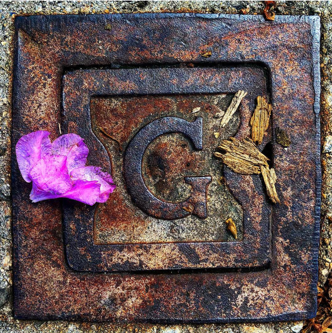 G for gas, complete with an artful flower petal.
