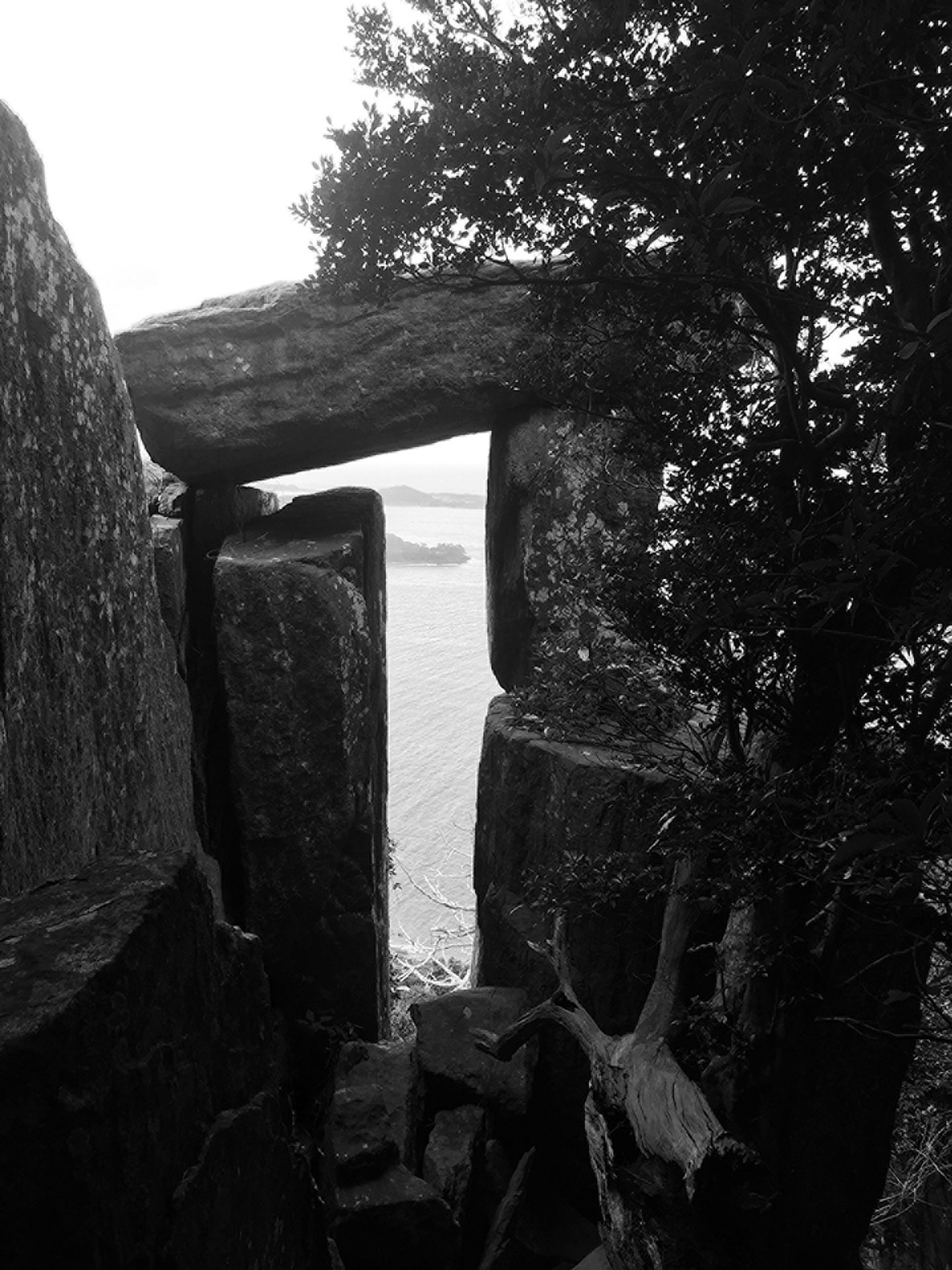 The view from a megalithic stone structure, which consists of pillars supporting a massive slab.