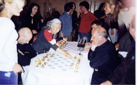 Saito takes on a fellow Fluxus partygoer in a game of Canapé Chess. 