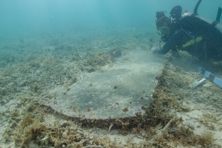 University of Miami graduate student Devon Fogarty examines the headstone of John Greer, who died while working at Fort Jefferson on Nov. 5, 1861. The gravesite is now completely underwater.
