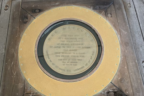 This plaque reads "Over this spot on 2 September 1945 the instrument of formal surrender of Japan to the allied powers was signed thus bringing to a close the second world war. The ship at that time was at anchor in Tokyo bay"