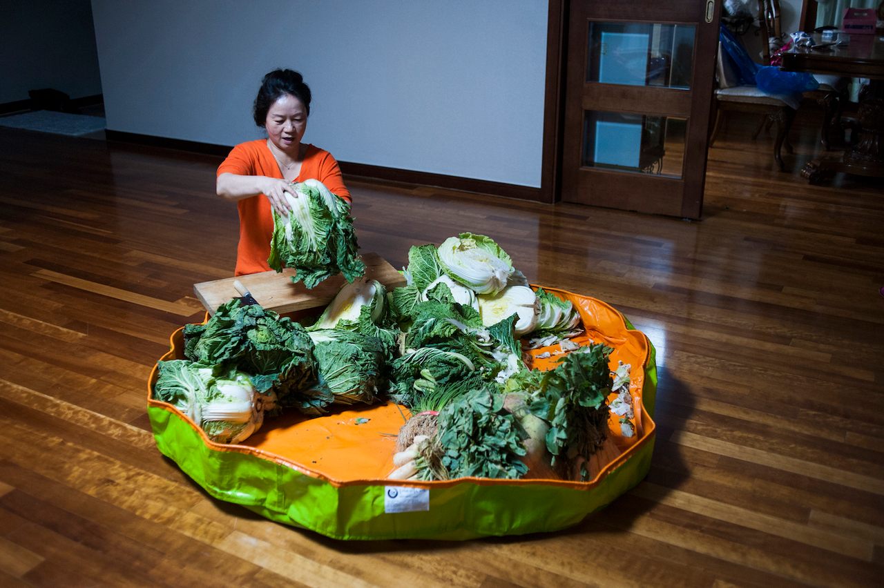 Photographer Sangsuk Sylvia Kang's mother Kyung Ae Lee performs <em>kimjang</em>, the practice of making kimchi, at her home in South Korea. 