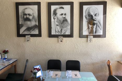 Lenin, Marx, and Engels watch over diners.