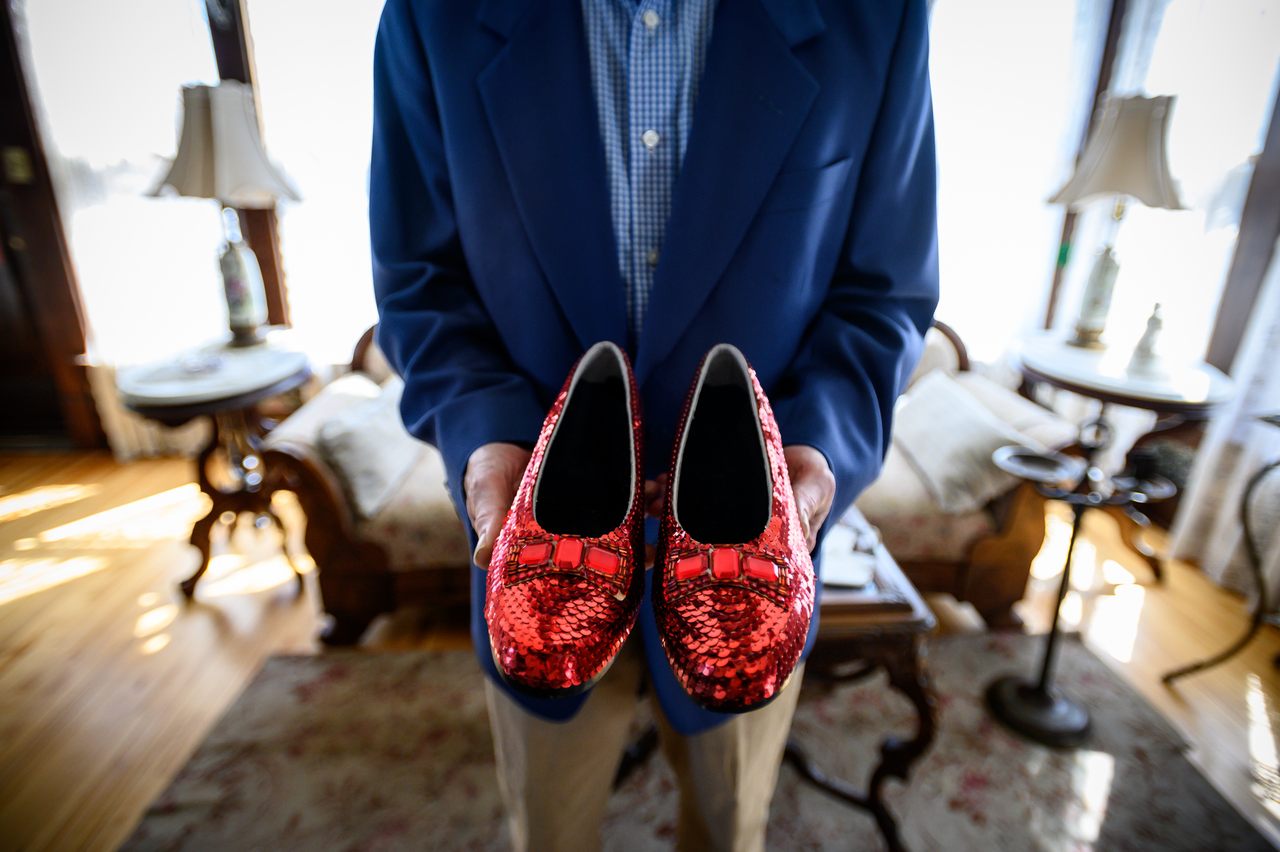 John Kelsch poses in the Judy Garland Museum with a replica of Garland's ruby slippers. The originals were stolen in 2005 and recovered in 2018.