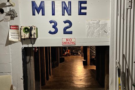 Small white tunnel entrance inside a building with the words "Mine 32" above in large, blue letters.