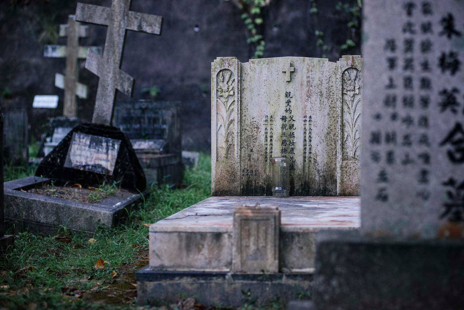 Some graves blend Christian and Chinese death traditions -- like this Christian tombstone with an incense bowl at its base.