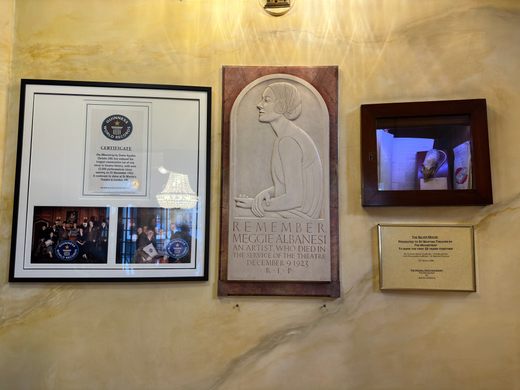 A marble wall with four awards