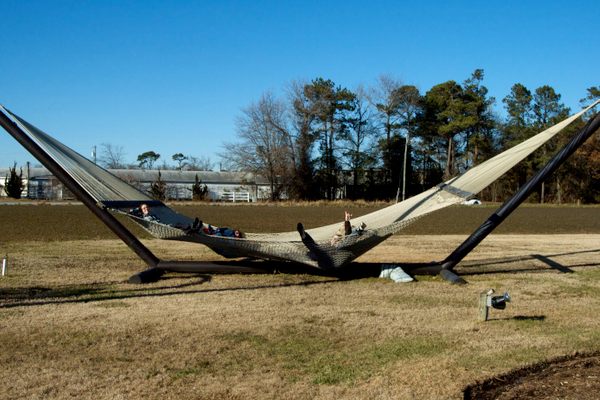 The world's largest hammock, containing four adults for scale.