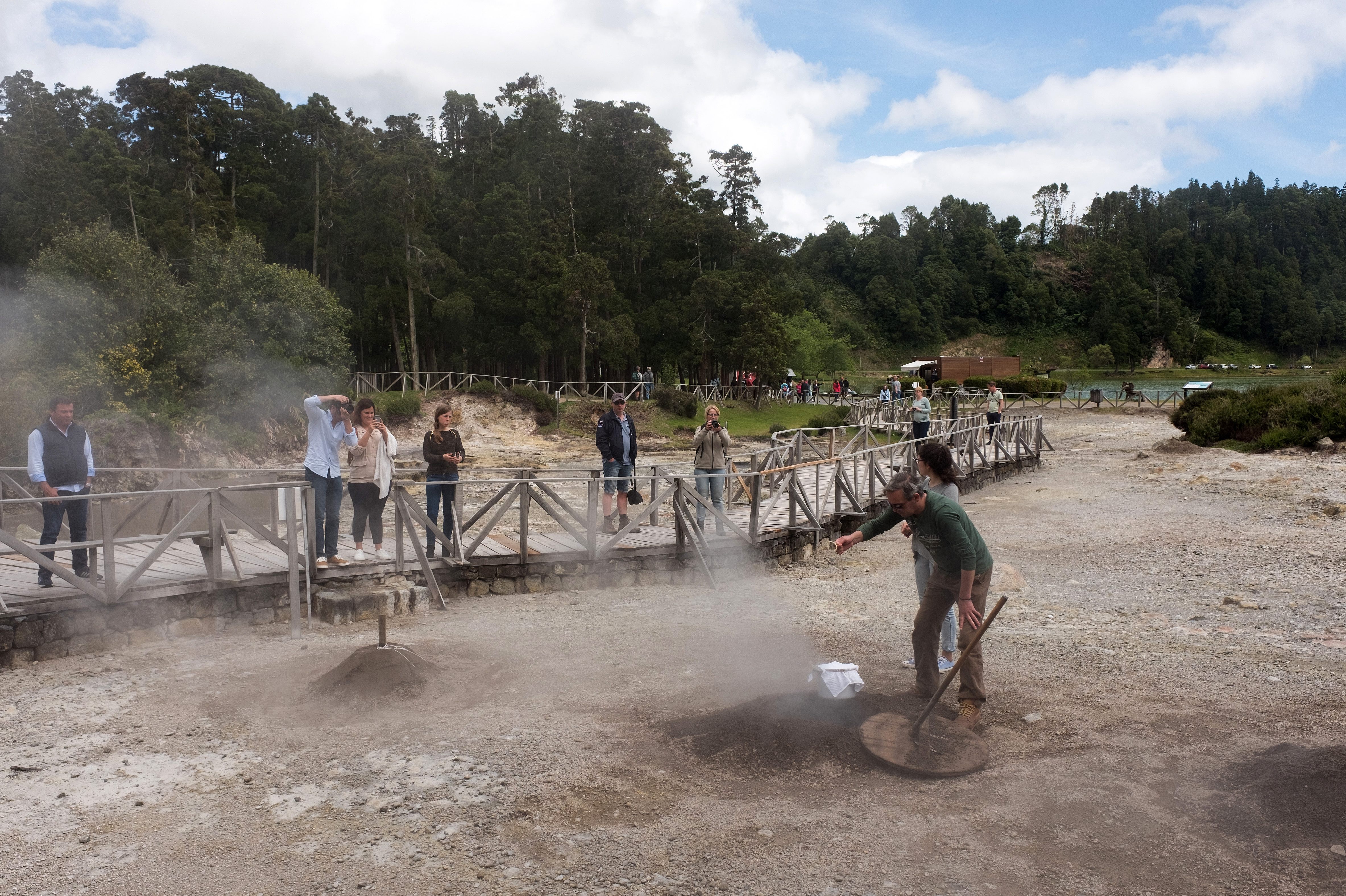 Visitors observe the pits where pots of cozido are buried.