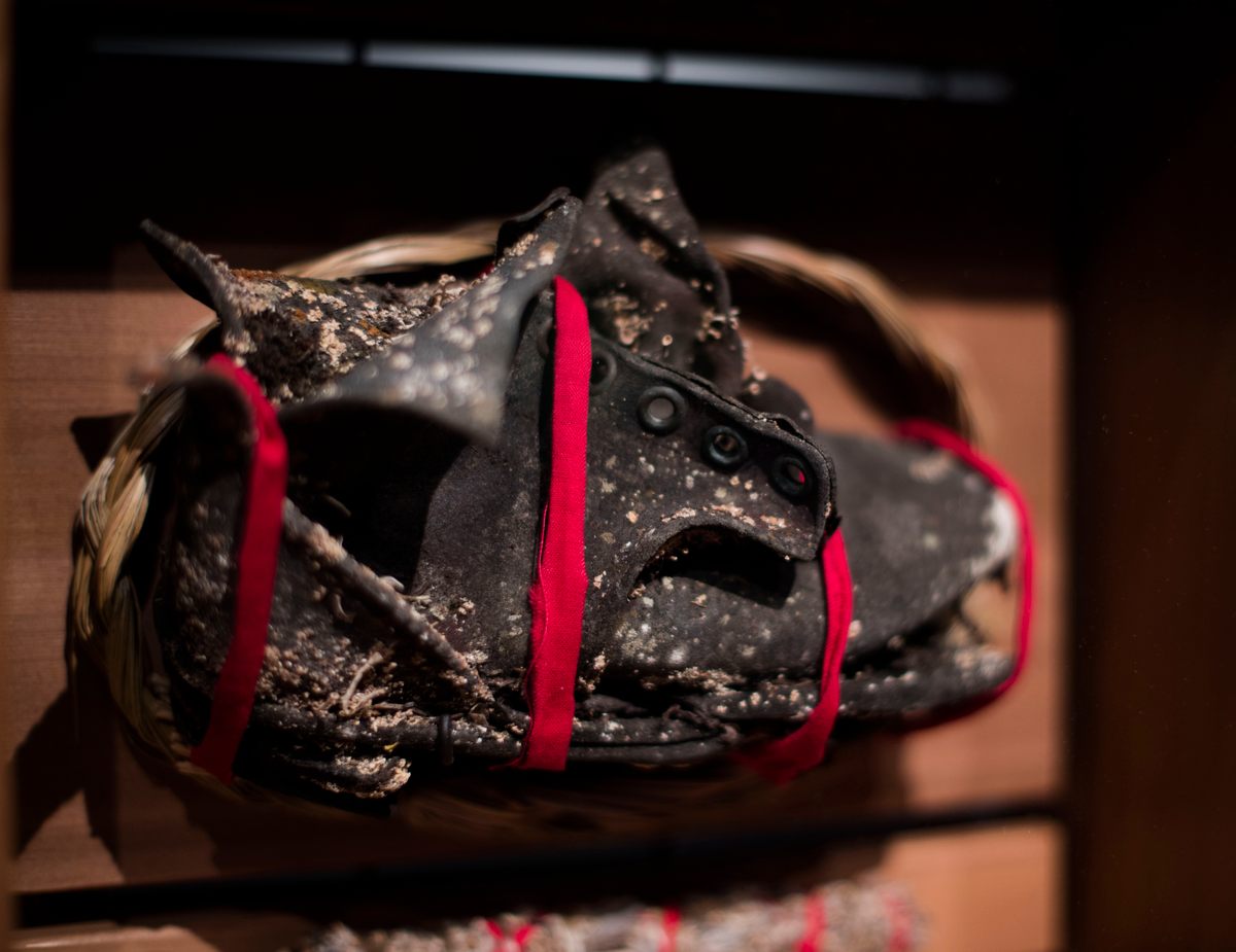 Project coordinator Rosy Hartman found this child's shoe at a former school site Carcross, Yukon. It's now part of the Witness Blanket, wrapped in red medicine cloth and surrounded by sage and sweetgrass.