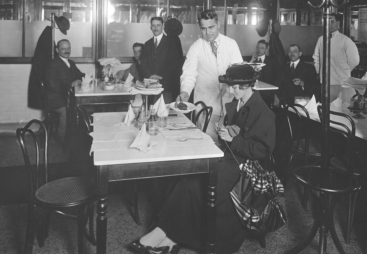 A woman knits while waiting to be served at a restaurant in Waterbury, Connecticut, 1918.