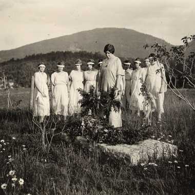 Alice Paul and other feminist mourners stand at Inez Milholland's grave.