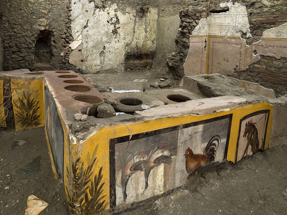 The thermopolium's counter with animal frescoes and embedded dolia.
