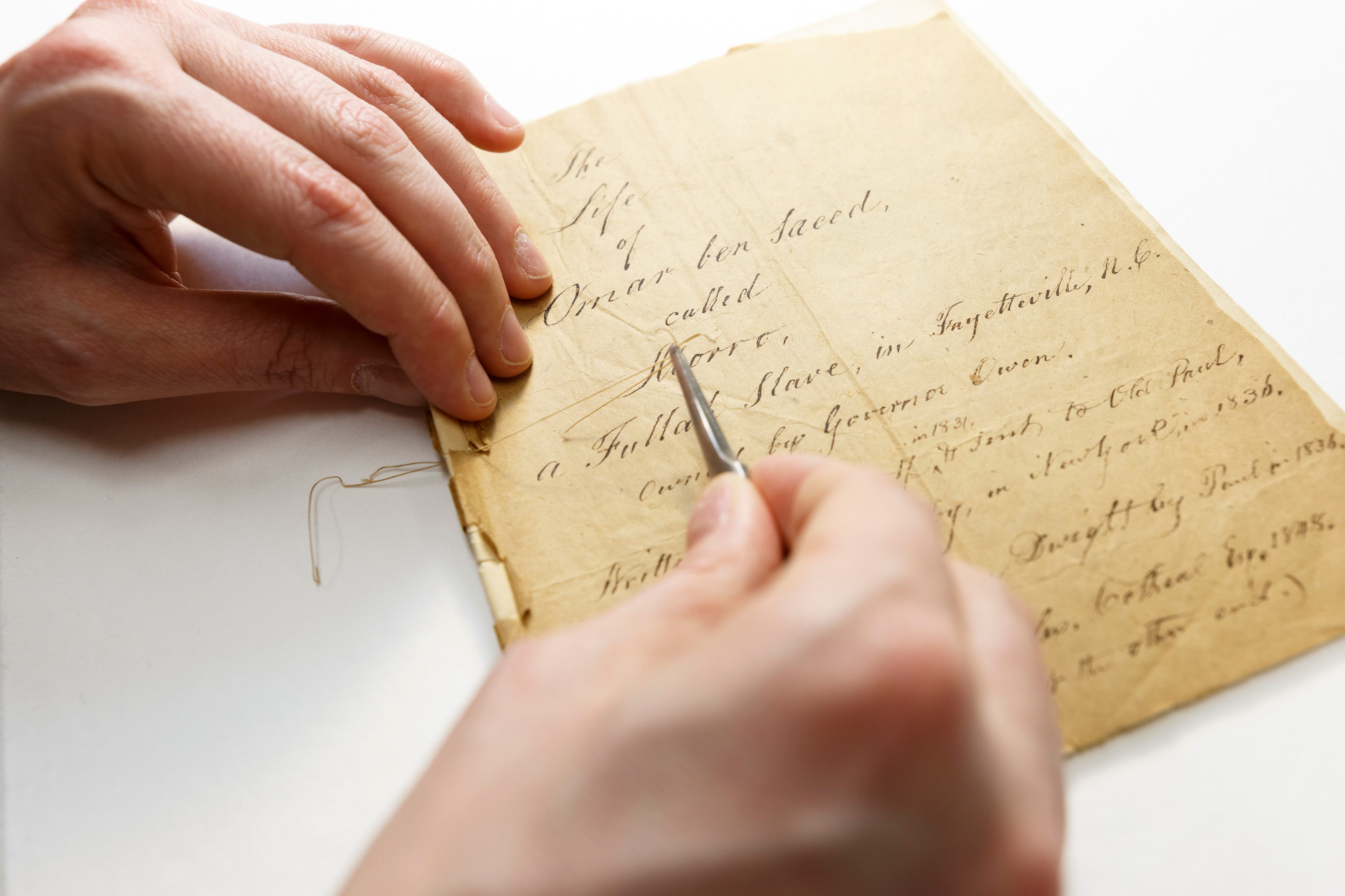 Conservator at the Library of Congress mending and reinforcing the Said manuscript.