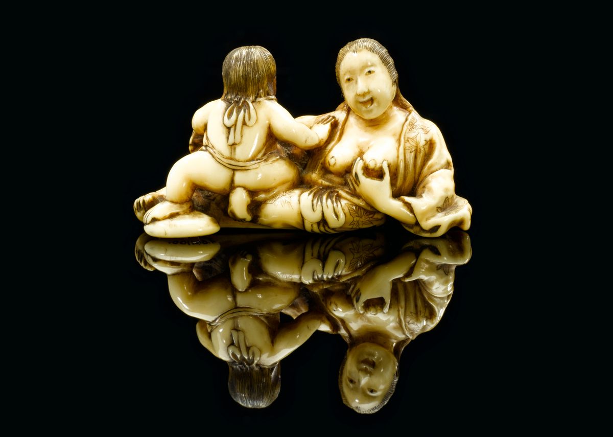 A netsuke depicting a mother breastfeeding her child.