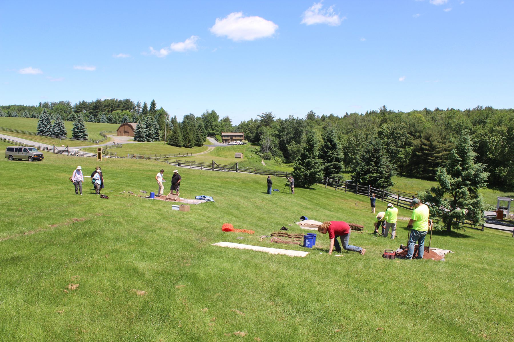 Archaeologists excavate test units in the general area of the stage.