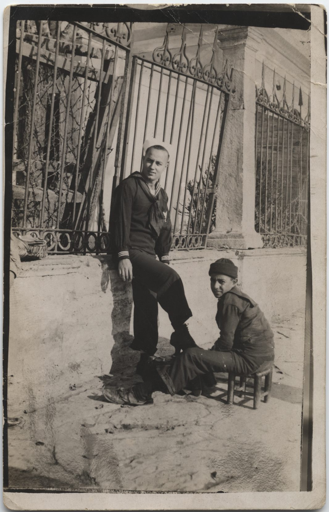 In Constantinople (now Istanbul), Turkey, a Turkish boy shines the shoes of American serviceman Louis A. Immediato, a ship's cook on USS <em>Barker</em>.