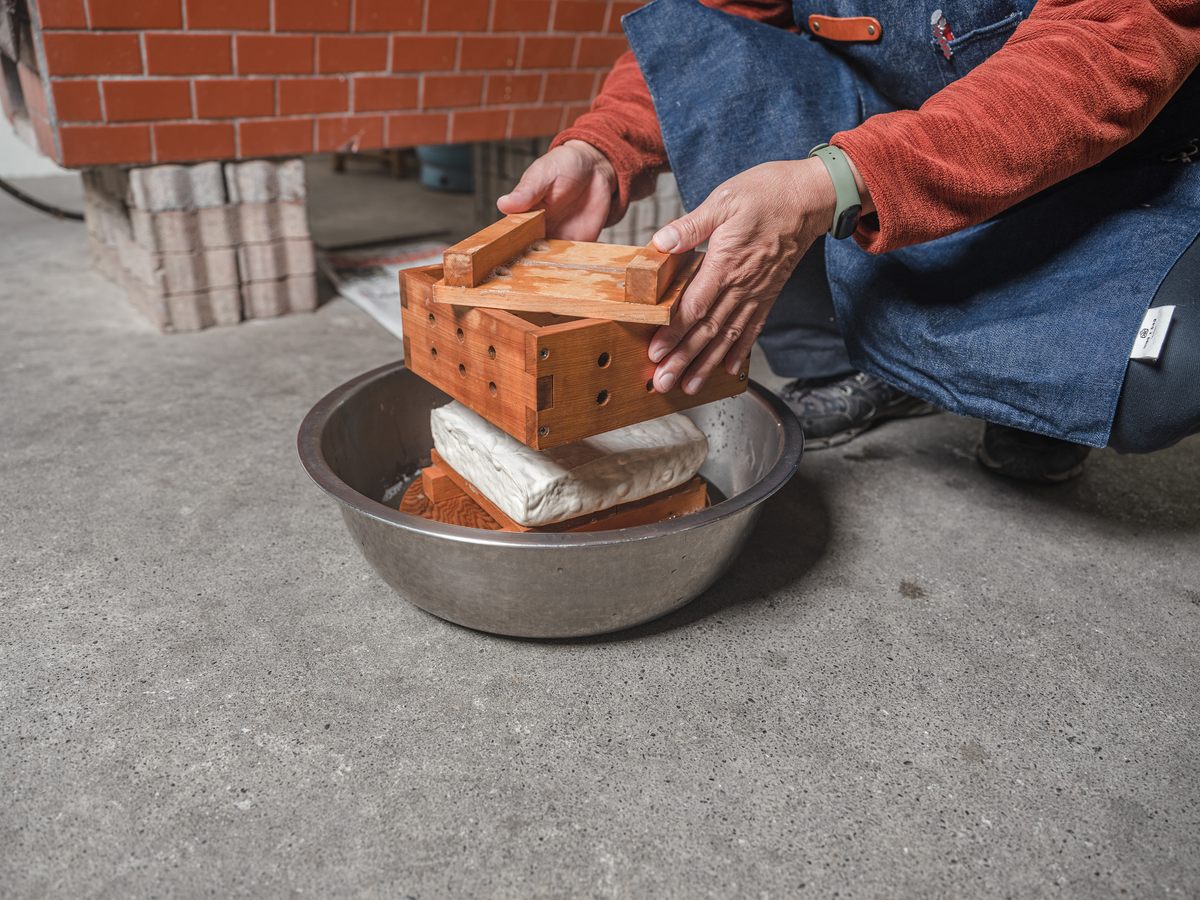 The pressure and the mould give the tofu its shape.