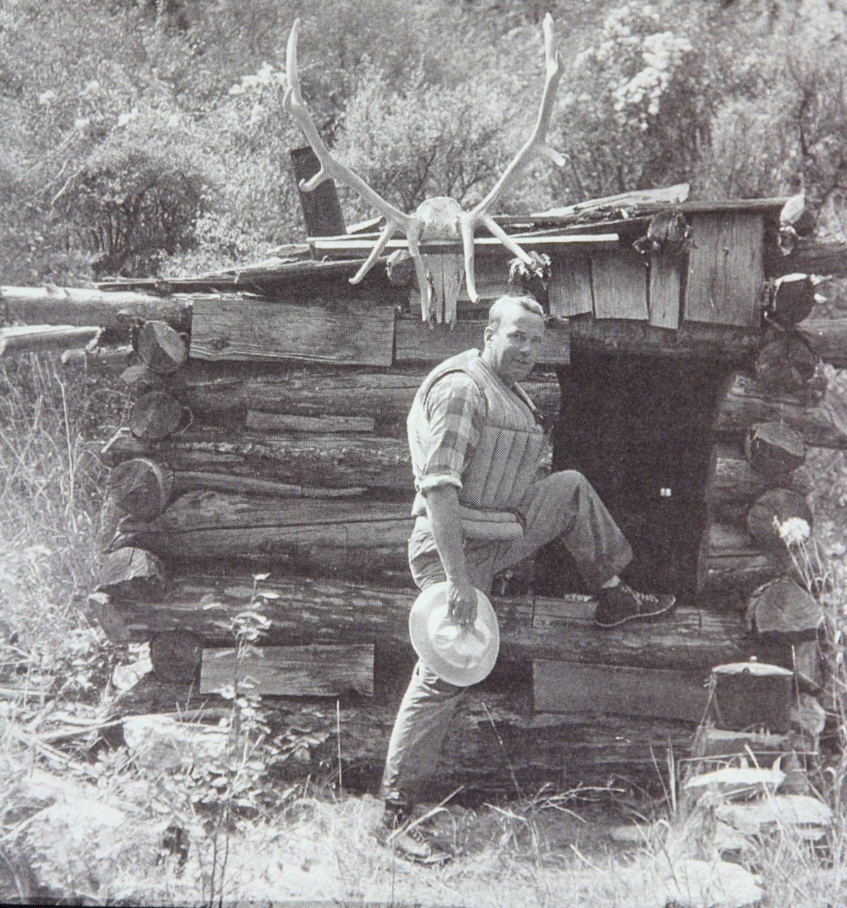 A member of the Hatch-Swain-Frazier Expedition stands in front of Parrott’s Lower Cabin on the Middle Fork Salmon River in 1936.