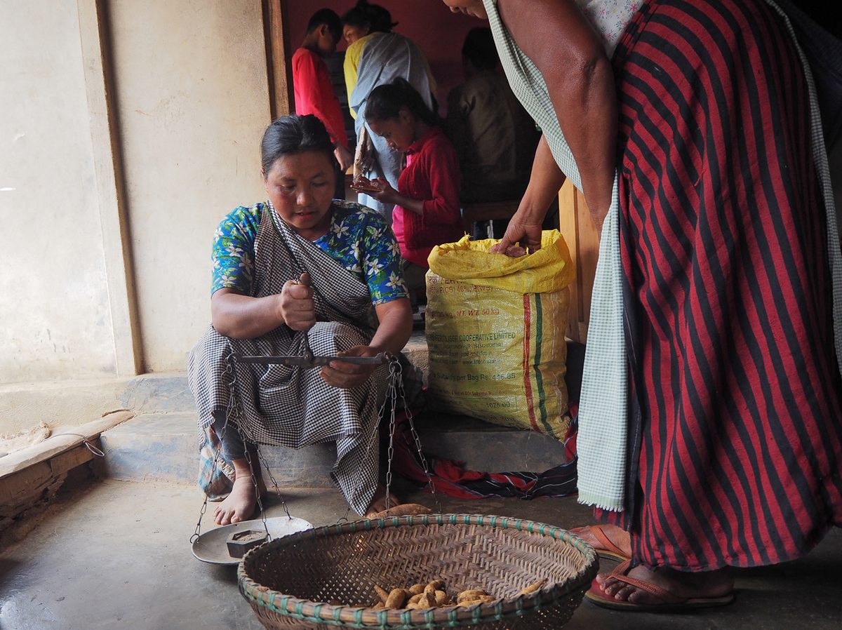 A farmer from Khweng Village stops at Plantina Mujai’s cafe to sell their yams.